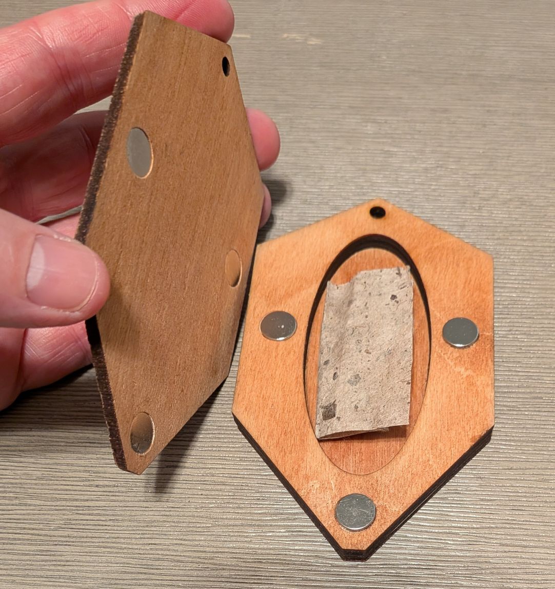 The inside of a wooden conference page that shows a hidden compartment with a slip of paper in it